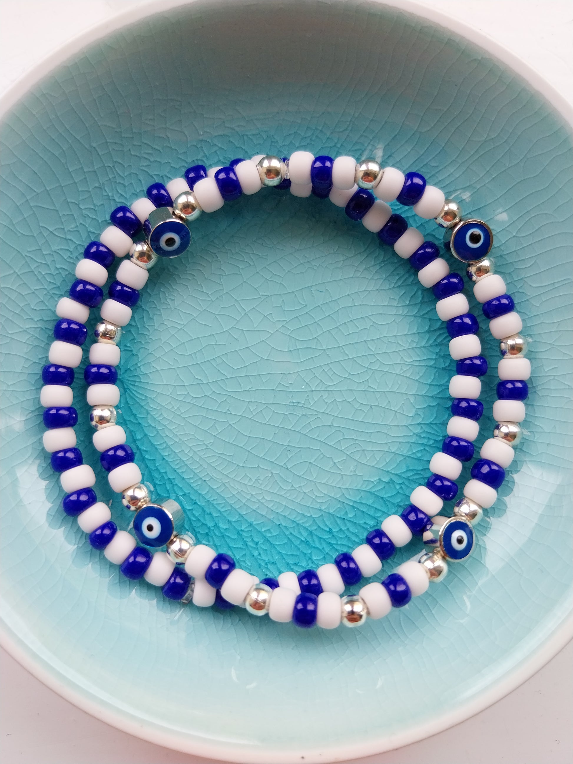 2 Blue and white bead bracelets one features evil eye charm beads