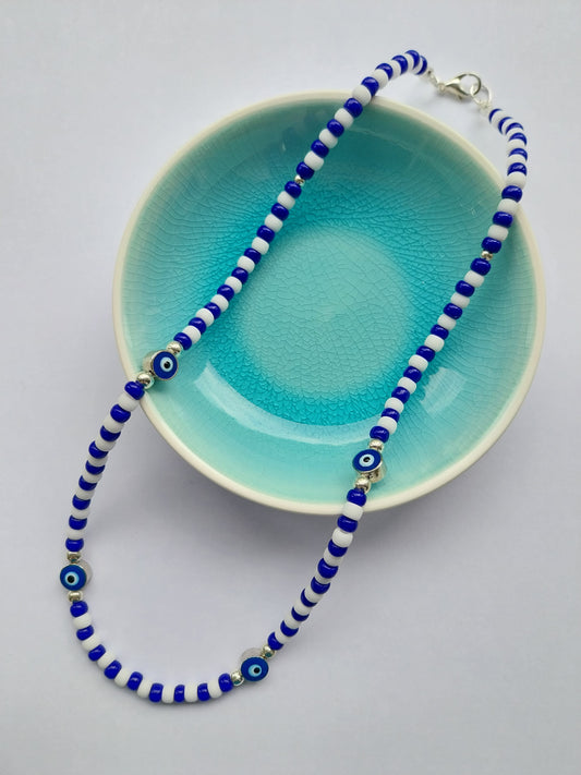 blue and white bead necklace featuring blue and white evil eye charm beads