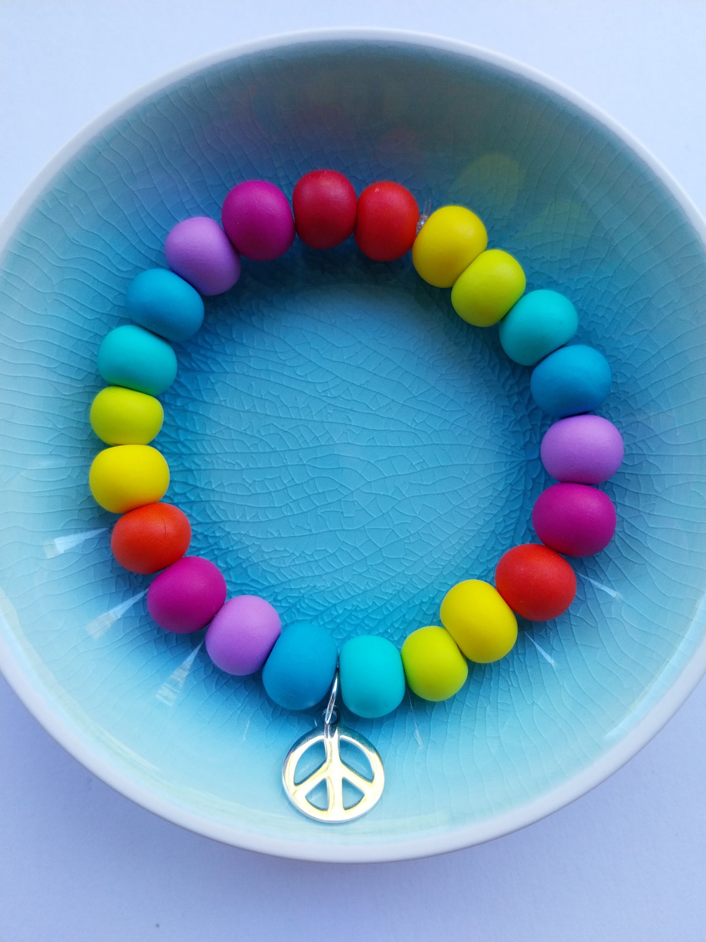 Multi-coloured clay bead bracelet with peace charm