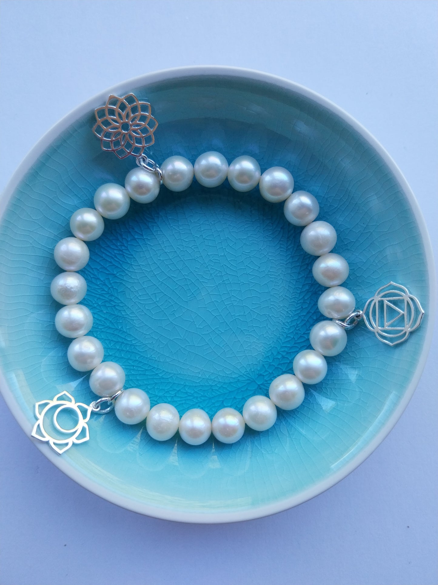 Pearl bracelet with 3 chakra silver charms