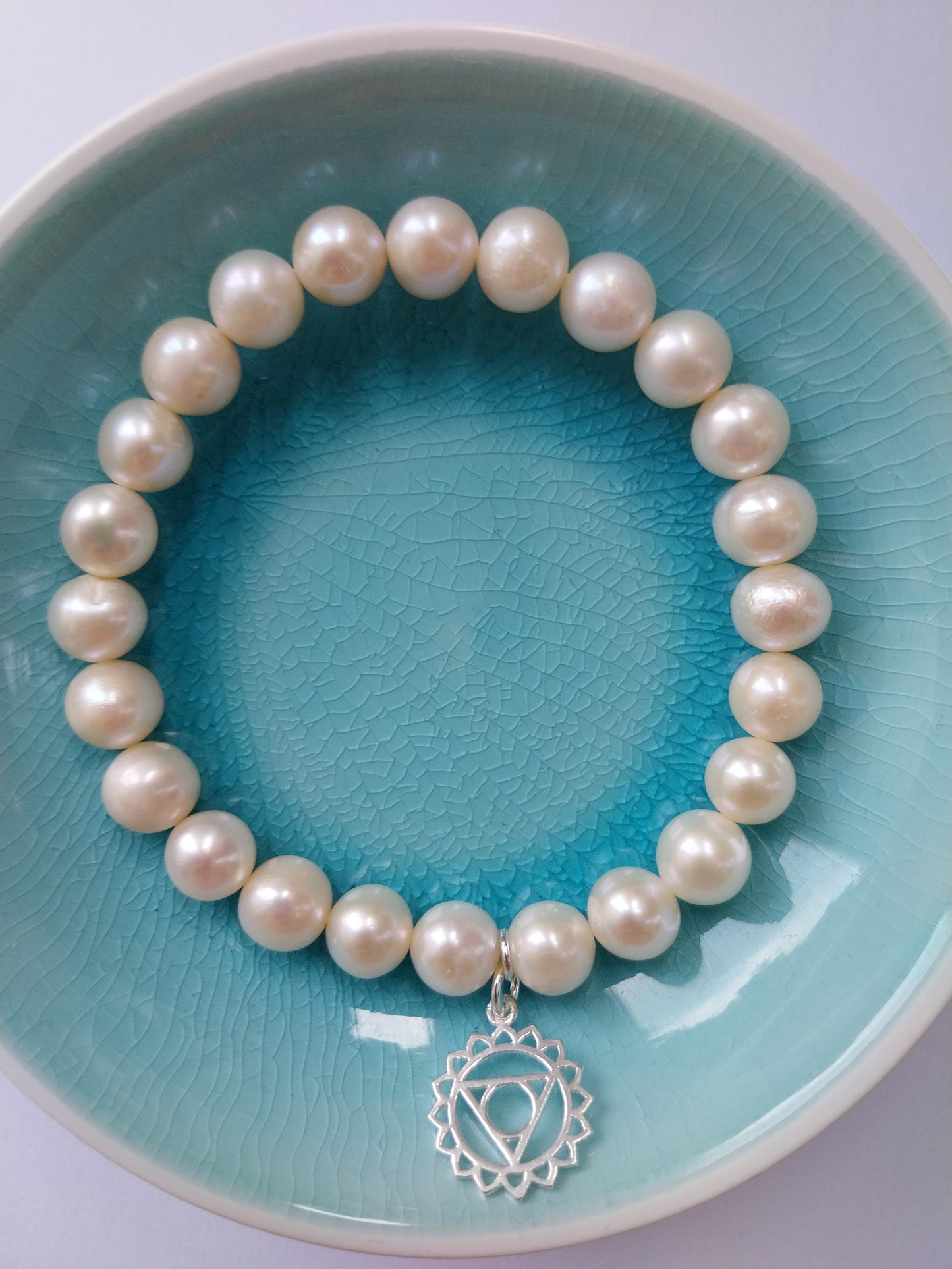 Pearl bracelet with throat chakra silver charm