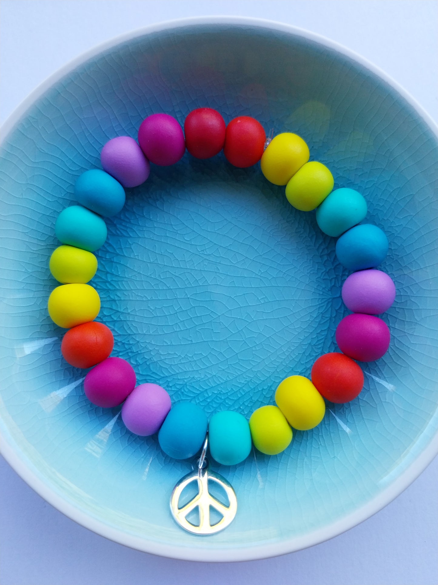 Rainbow coloured clay bead bracelet with silver peace charm