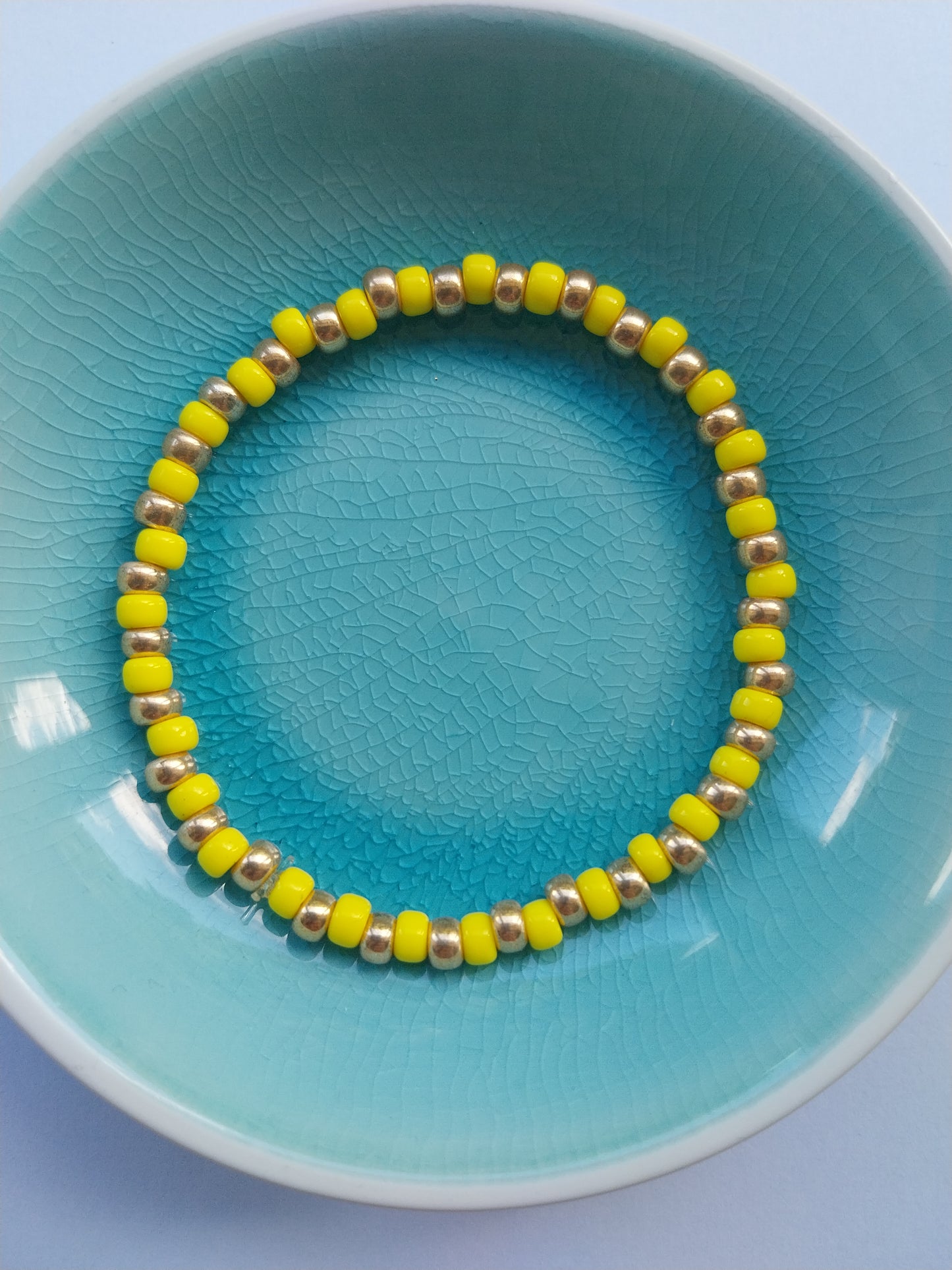 Stretchy bracelet with yellow and gold glass beads