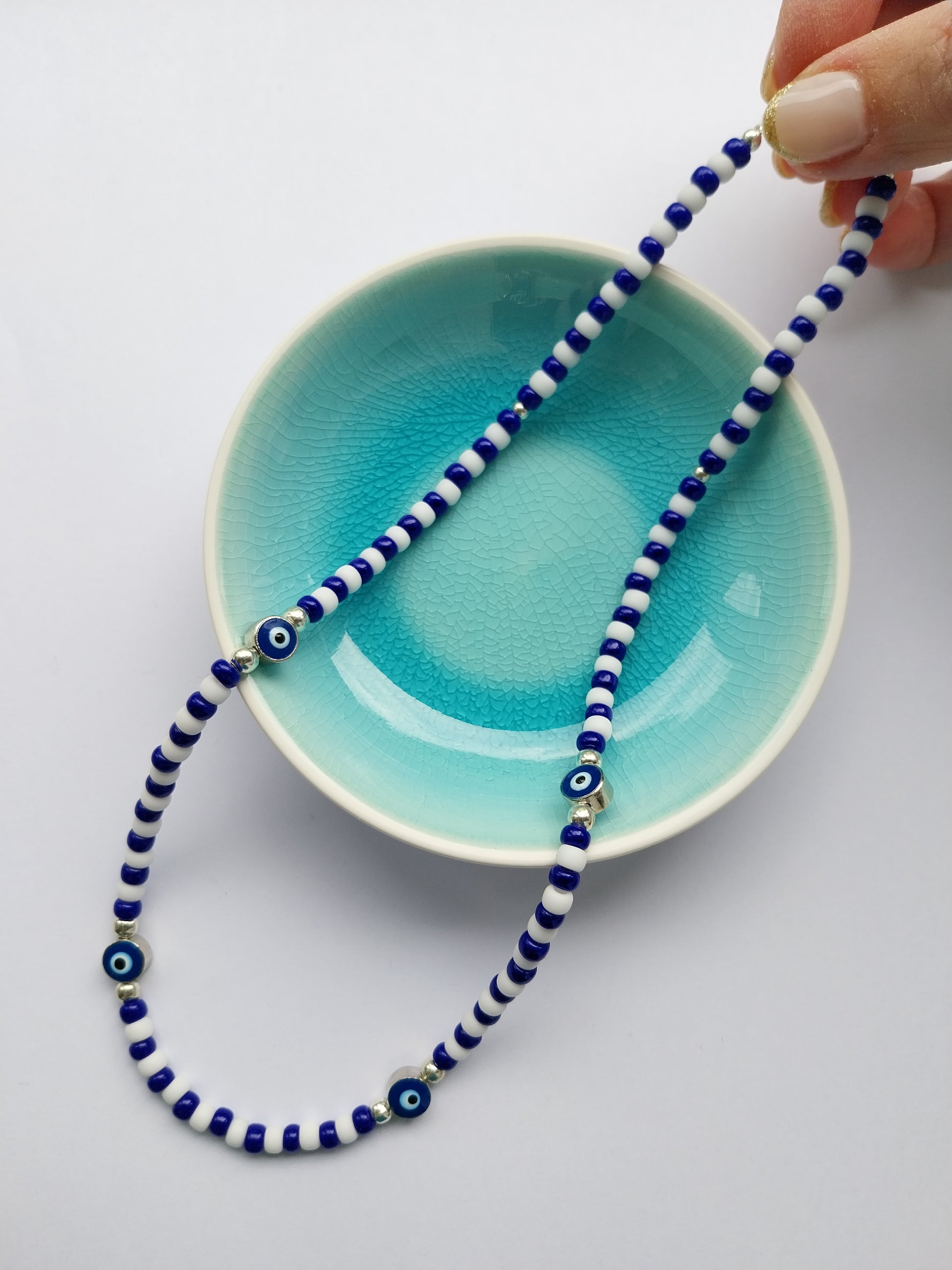 Blue and white bead necklace featuring evil eye charm beads