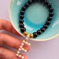 Black beaded agate bracelet with a pearl dangly letter E and gold patterned beads