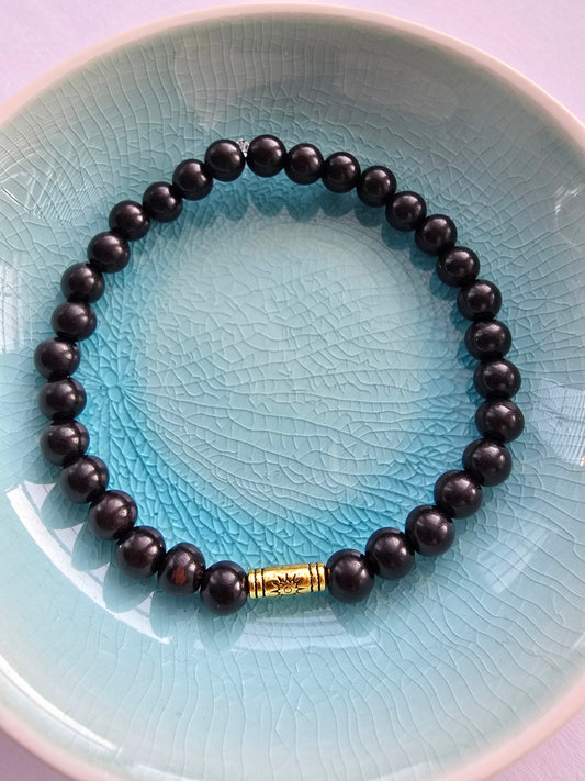 Wooden Ebony Black beaded bracelet with a gold Tibetan tube bead 
