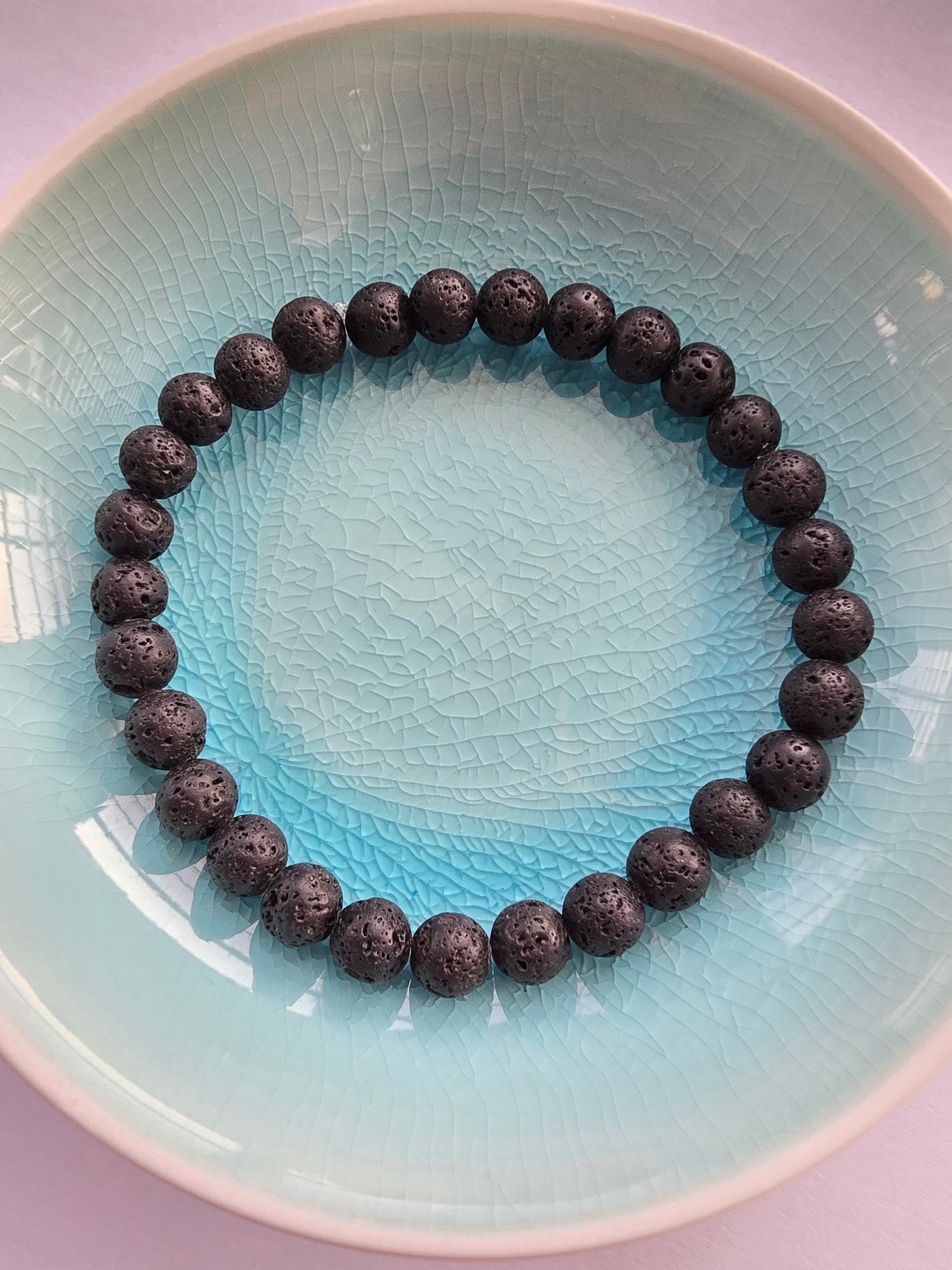 Lava stone bracelet on a light blue plate
