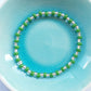 Elasticated bracelet with green and crystal glass beads