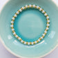 Glass bead stretchy bracelet in gold and pearlescent