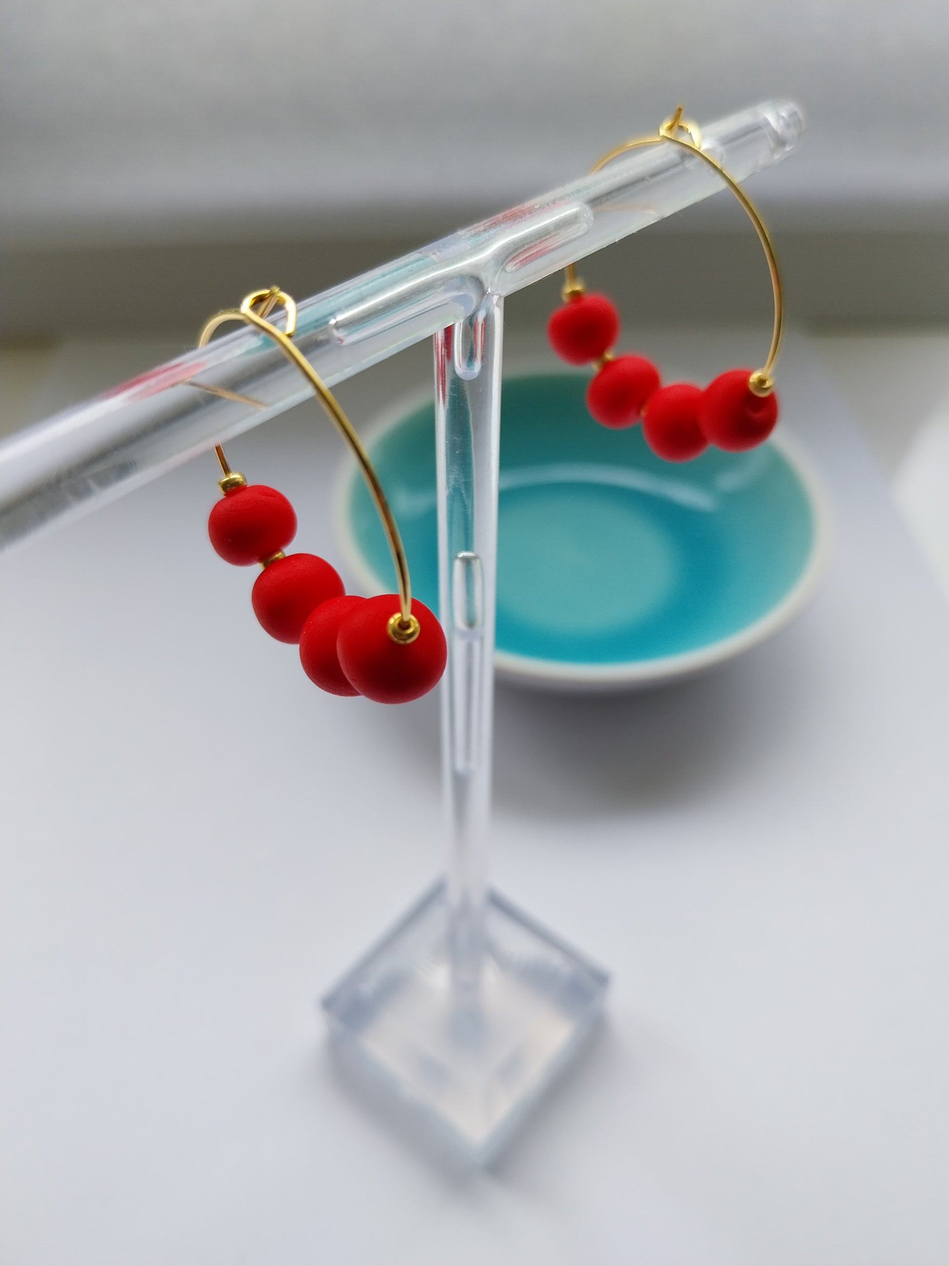 Gold hoop earrings with orange red clay beads