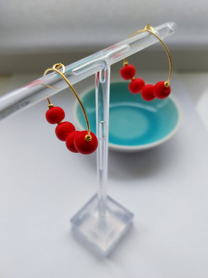 Gold hoop earrings with orange red clay beads