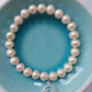 Pearl bracelet with throat chakra silver charm