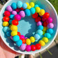 Rainbow coloured clay bead bracelets stacked together