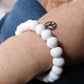 White clay bead bracelet with silver peace charm