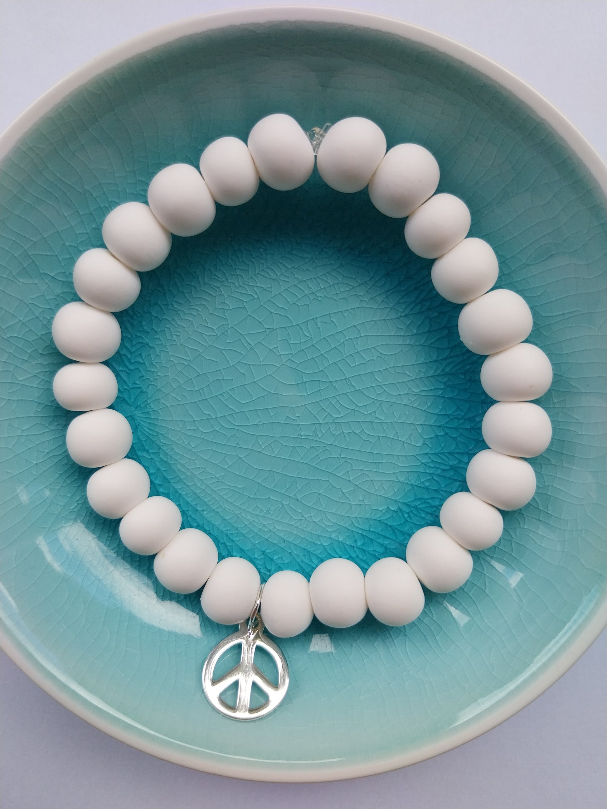 White clay bead bracelet with sterling silver peace charm