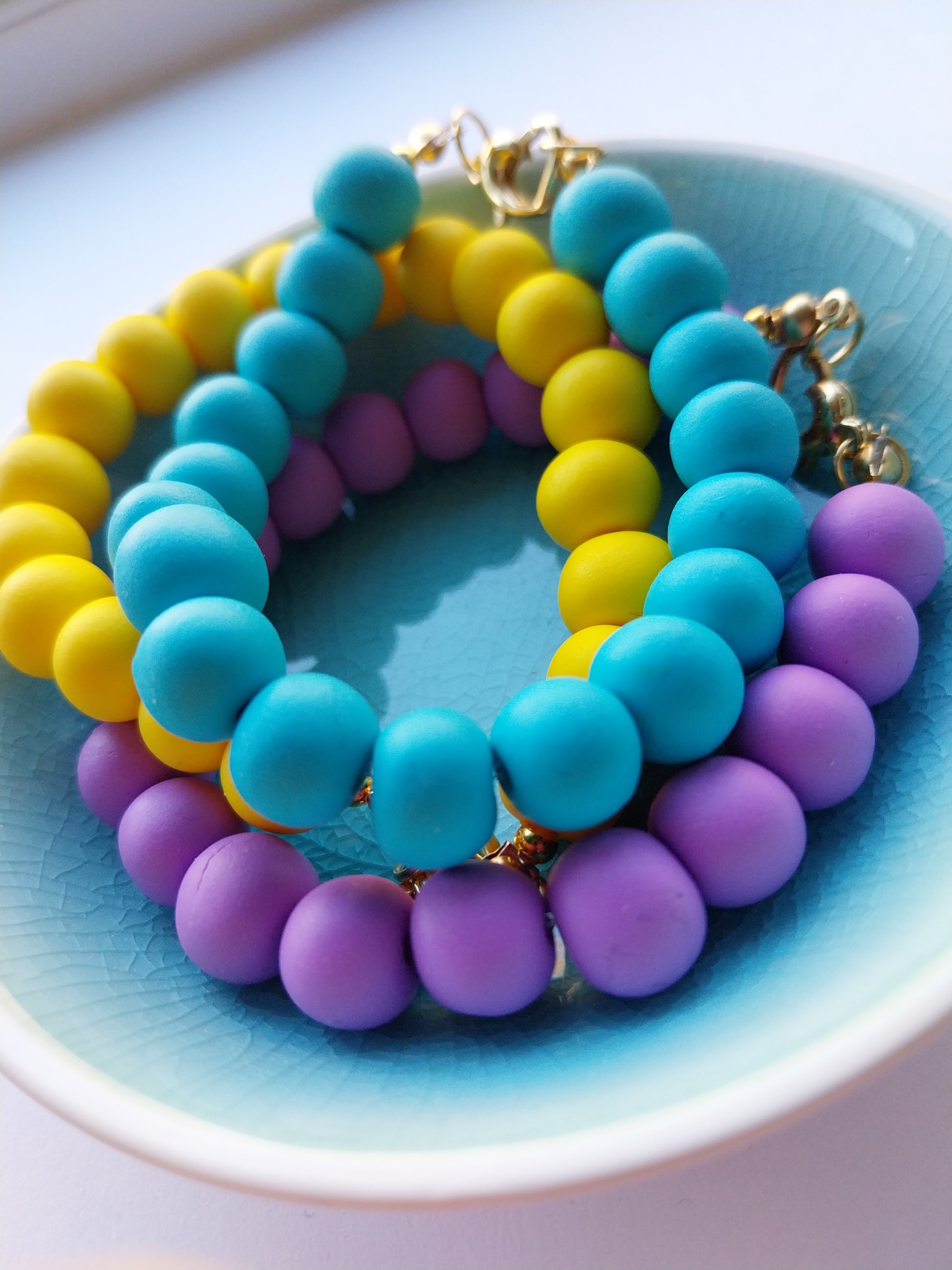 Colourful clay bead bracelets with gold plated heart clasp