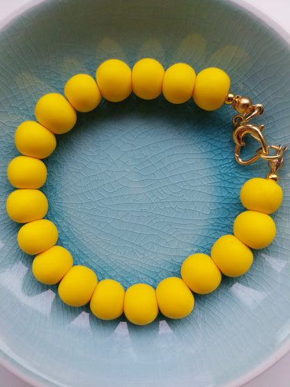 Vibrant yellow polymer clay bead bracelet with gold plated heart shaped clasp