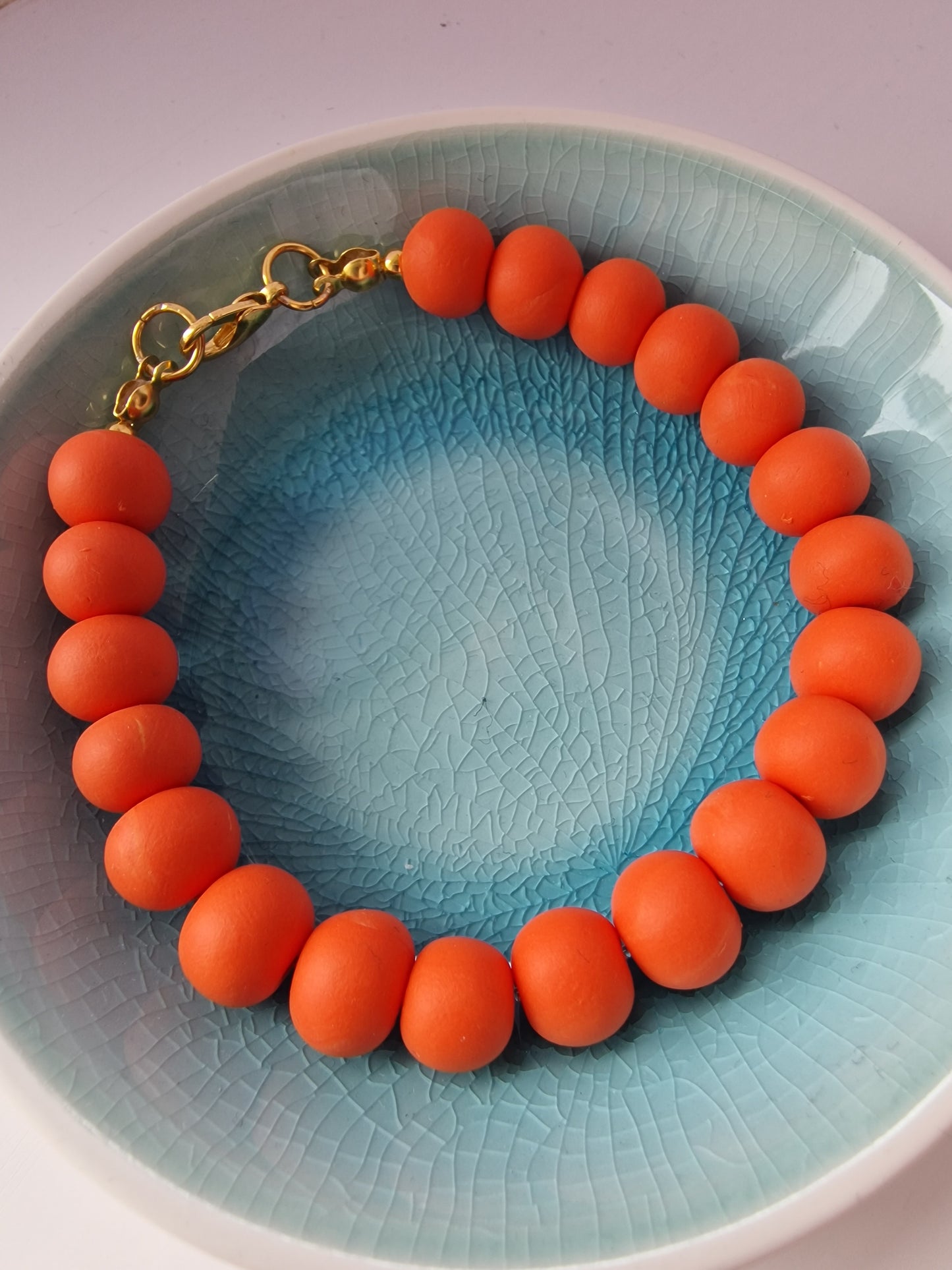 Colourful orange clay bead bracelet with gold plated clasp