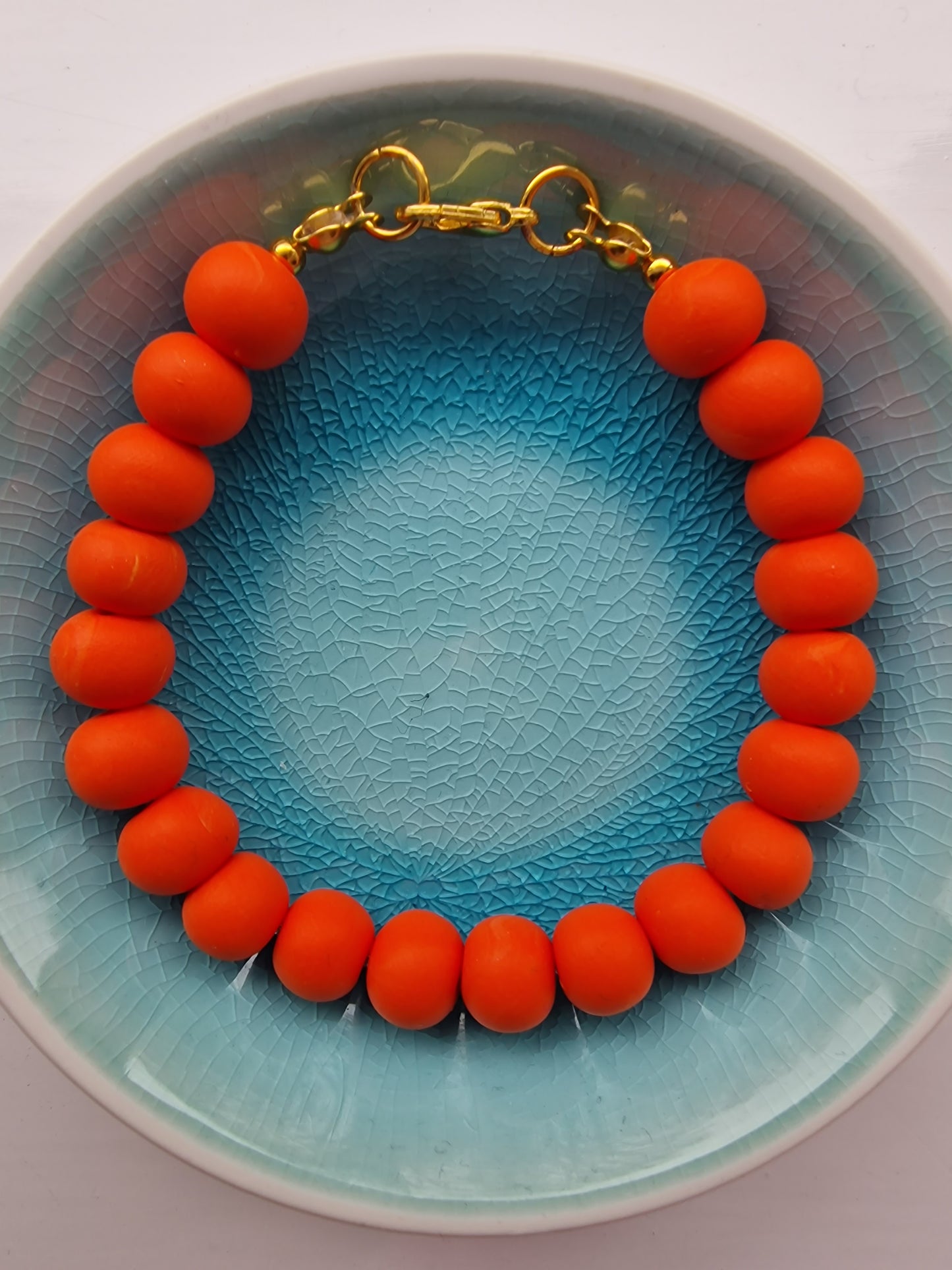 Colourful orange clay bead bracelet with gold plated clasp